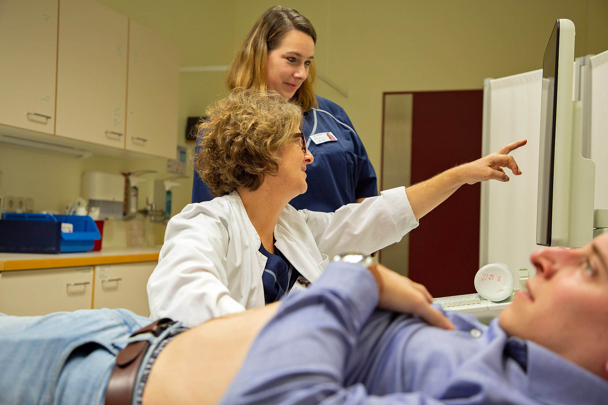 Patient bei urologischer Untersuchung mit Ärztin und Pflegekraft